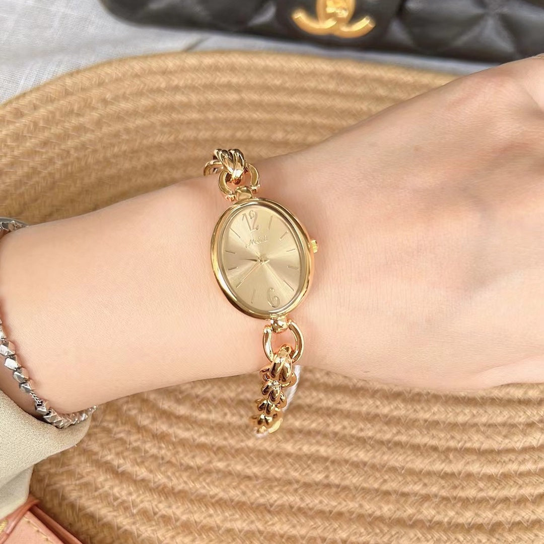 Reloj de pulsera de cuarzo con correa de acero dorada ovalada calada para mujer