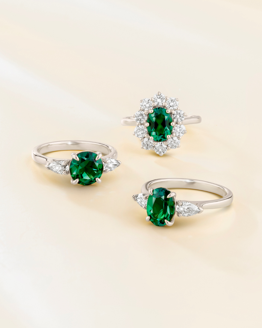 Anillo de compromiso de tres piedras con corte redondo de esmeralda en plata de ley