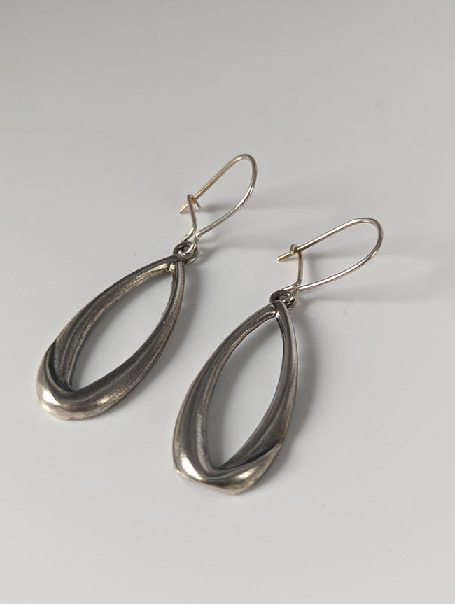 Pendientes ovalados con soga y detalle caído de caballo plateado
