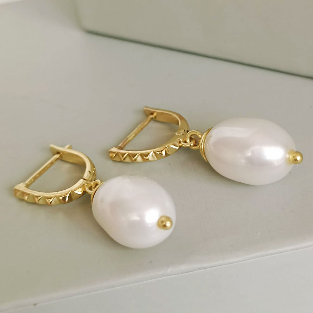 Pendientes Diani de perlas tipo huggie con tachuelas