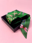 Pañuelo de seda satinada 'Greenery' con estampado floral, insectos y piedras preciosas en color verde