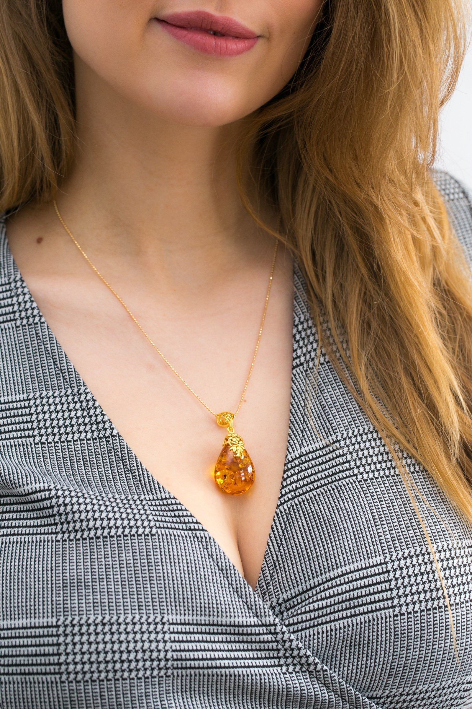 Colgante con gota ámbar y acento floral dorado